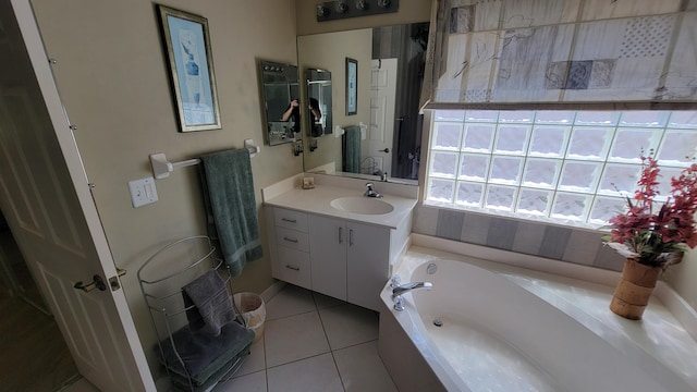 bathroom featuring tile patterned flooring, a tub, and vanity