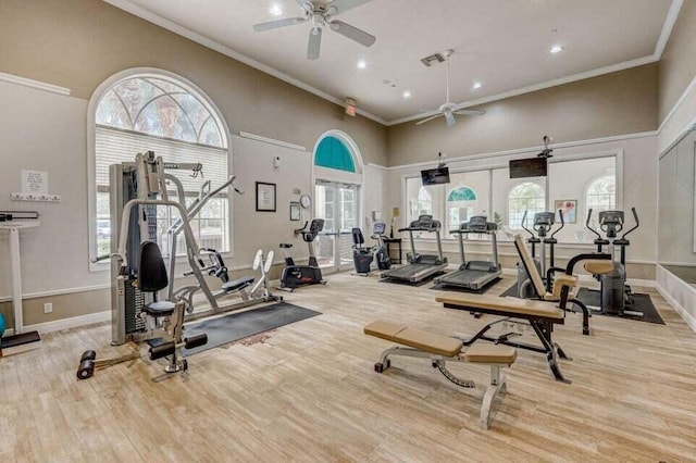 exercise room featuring crown molding, french doors, light hardwood / wood-style flooring, a high ceiling, and ceiling fan