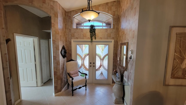 tiled foyer entrance featuring high vaulted ceiling