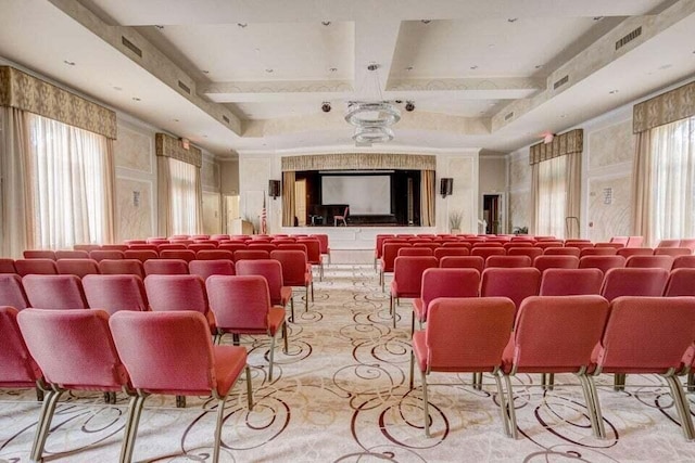 cinema featuring a raised ceiling and coffered ceiling