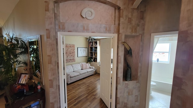 hallway featuring high vaulted ceiling and hardwood / wood-style floors