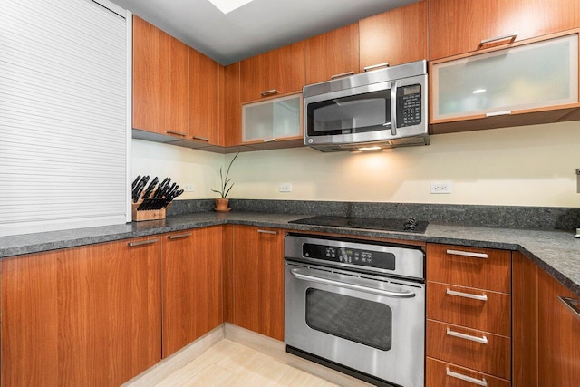 kitchen with appliances with stainless steel finishes and dark stone countertops