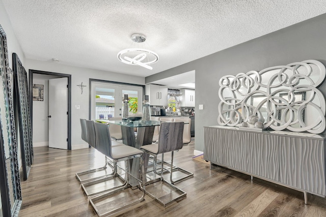 dining area featuring a textured ceiling, hardwood / wood-style flooring, and french doors