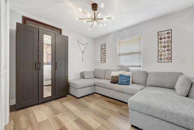 living room featuring a notable chandelier and light wood-type flooring