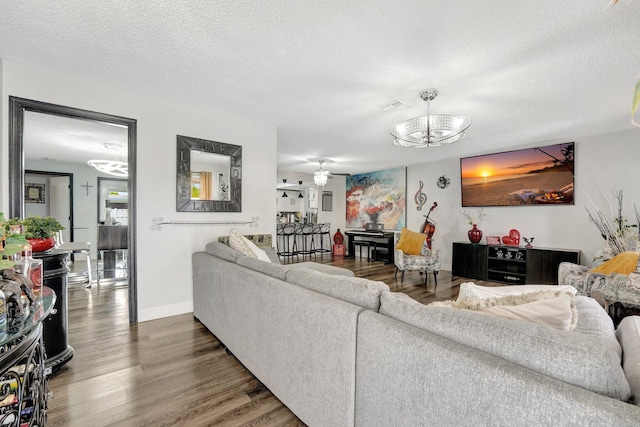 living room featuring ceiling fan, dark hardwood / wood-style flooring, and a textured ceiling