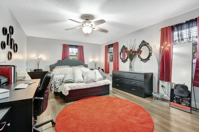 bedroom with light hardwood / wood-style floors and ceiling fan