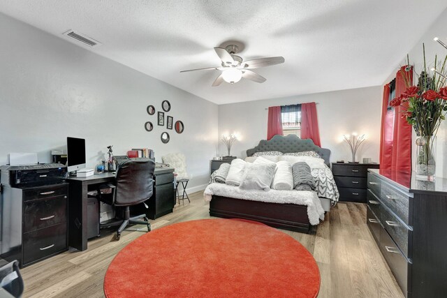 bedroom featuring a textured ceiling, light hardwood / wood-style flooring, and ceiling fan