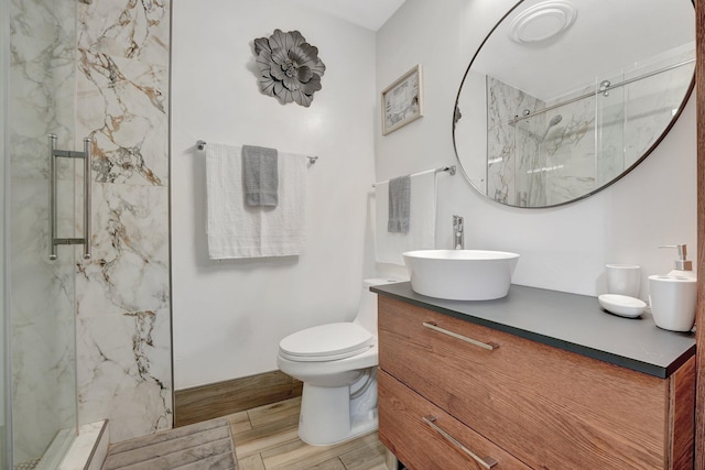 bathroom with vanity, a shower with shower door, and toilet