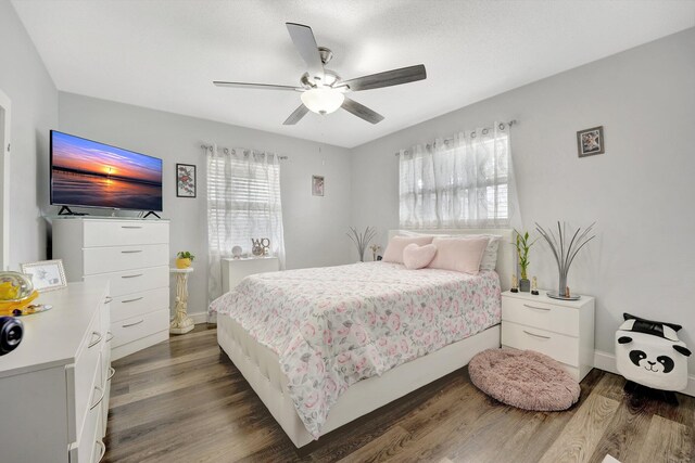 bedroom with dark hardwood / wood-style flooring and ceiling fan