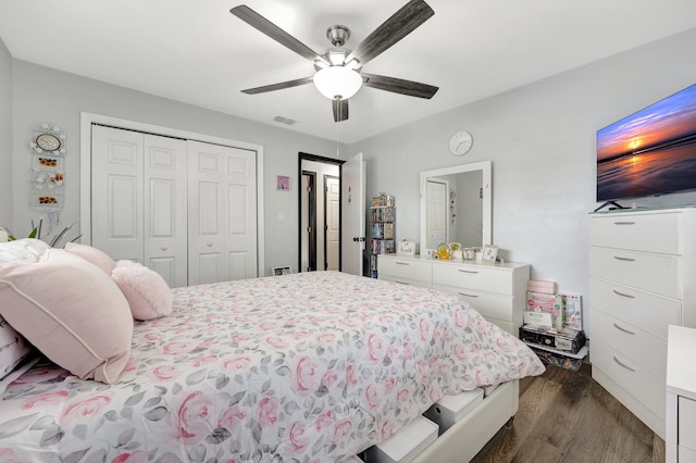 bedroom with dark hardwood / wood-style flooring, a closet, and ceiling fan