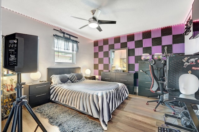 bedroom with light hardwood / wood-style flooring, a textured ceiling, and ceiling fan