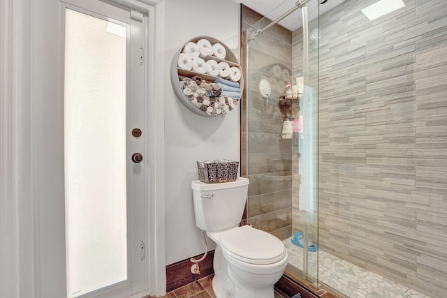 bathroom with toilet and an enclosed shower