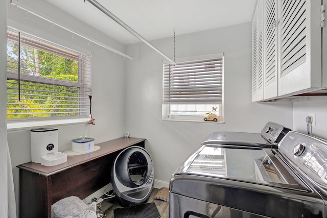 washroom with washer and dryer, cabinets, and hardwood / wood-style floors