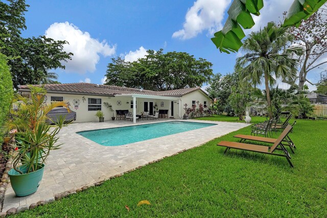 view of pool with a patio and a lawn