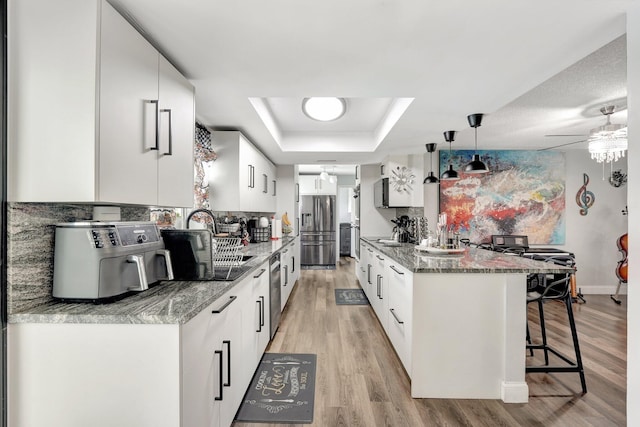 kitchen featuring light hardwood / wood-style floors, appliances with stainless steel finishes, and white cabinetry