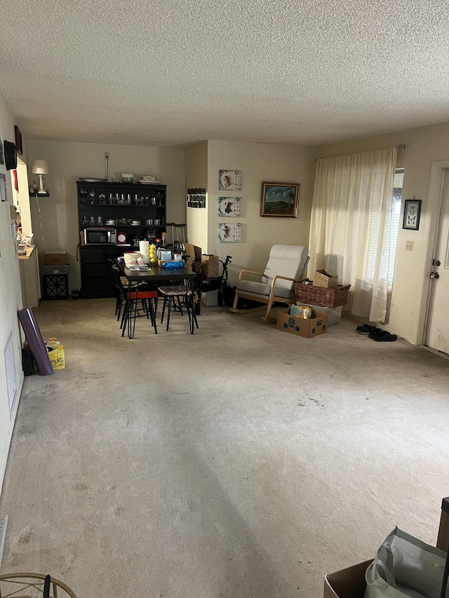 dining space with carpet and a textured ceiling