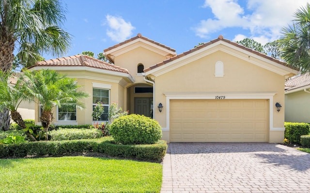 mediterranean / spanish-style home featuring a garage and a front lawn