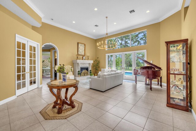 tiled living room featuring ornamental molding, a fireplace, french doors, and a chandelier