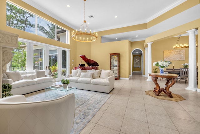 living room with decorative columns, an inviting chandelier, a high ceiling, light tile patterned floors, and ornamental molding