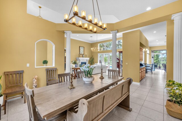 dining room with plenty of natural light, decorative columns, a towering ceiling, and light tile patterned floors