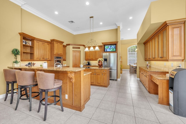 kitchen featuring appliances with stainless steel finishes, a kitchen island with sink, light stone countertops, a kitchen breakfast bar, and ornamental molding