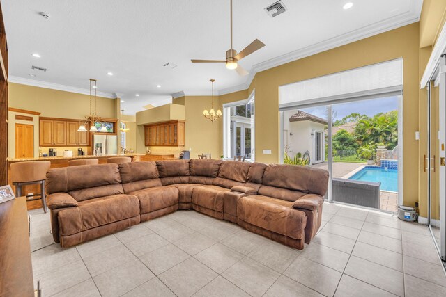 living room with ceiling fan with notable chandelier, ornamental molding, and light tile patterned floors