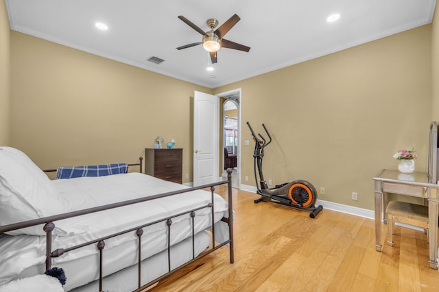 bedroom with ornamental molding, ceiling fan, and light wood-type flooring