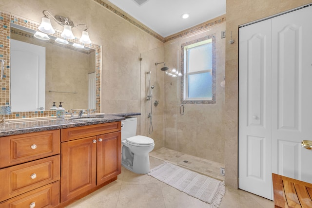 bathroom featuring vanity, tile walls, a shower with shower door, toilet, and tile patterned flooring