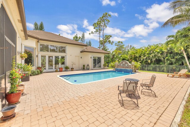 view of swimming pool featuring a patio area and french doors