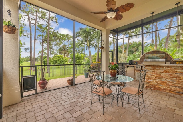 sunroom / solarium featuring ceiling fan