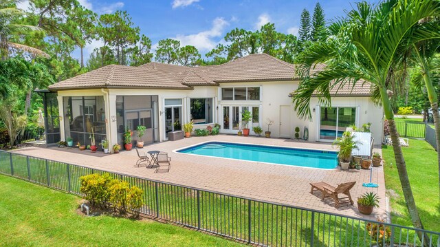 view of pool featuring a patio area, a sunroom, and a yard