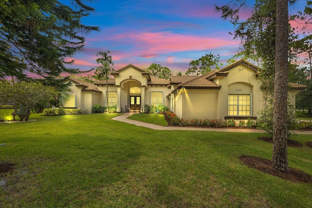 mediterranean / spanish house featuring a lawn