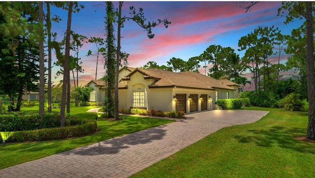 mediterranean / spanish house featuring a yard and a garage