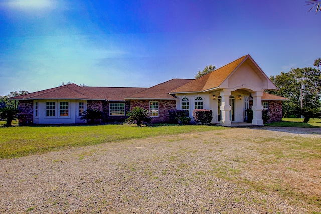 ranch-style home featuring a front lawn