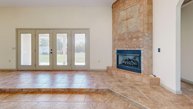 unfurnished living room featuring a fireplace, tile patterned floors, and french doors