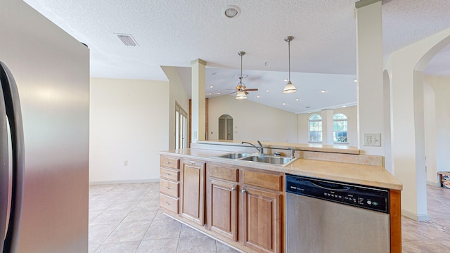 kitchen with sink, light tile patterned floors, vaulted ceiling, and stainless steel appliances