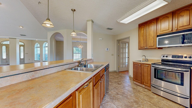 kitchen with decorative light fixtures, sink, appliances with stainless steel finishes, a textured ceiling, and light tile patterned floors