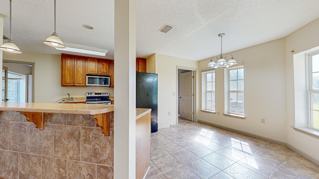 kitchen featuring a kitchen bar, stainless steel appliances, a wealth of natural light, and light tile patterned floors