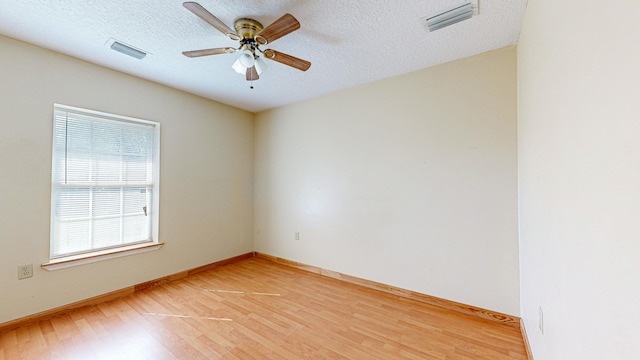 unfurnished room with a textured ceiling, wood-type flooring, and ceiling fan