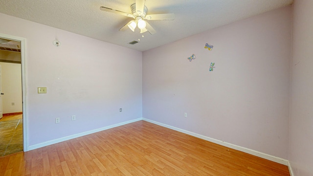 spare room featuring a textured ceiling, ceiling fan, and light hardwood / wood-style floors