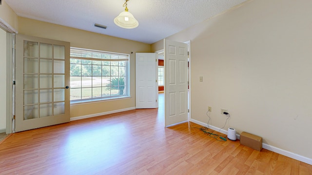 empty room featuring a textured ceiling and hardwood / wood-style flooring