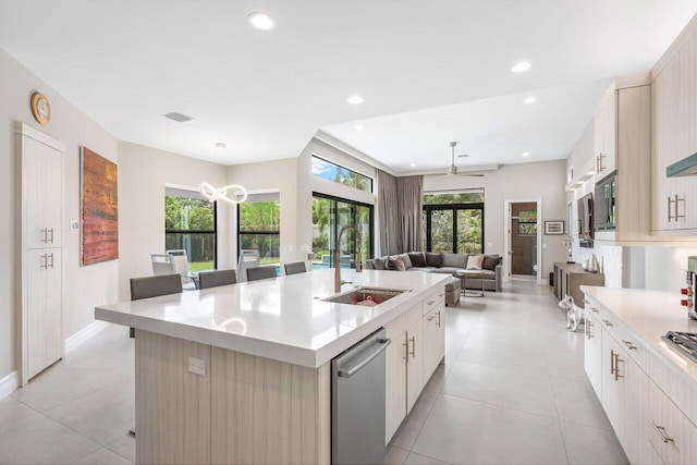 kitchen with a large island, sink, a kitchen bar, decorative light fixtures, and ceiling fan with notable chandelier