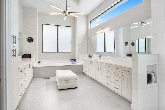 bathroom with vanity, tiled bath, and tile patterned flooring