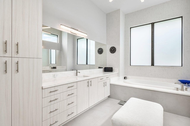 bathroom with vanity, tile patterned floors, and a bath