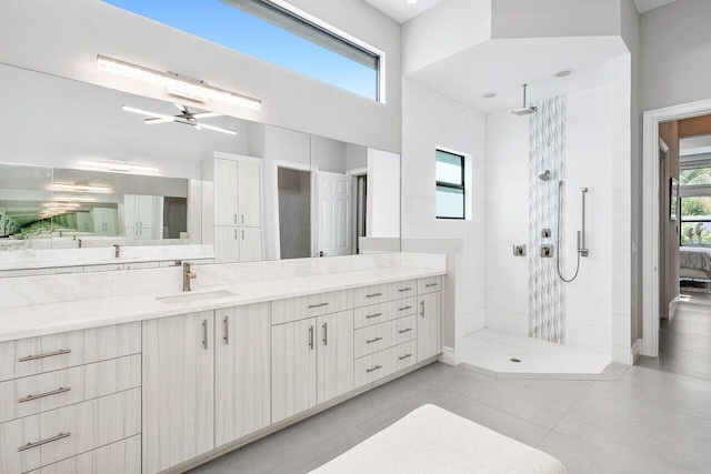 bathroom featuring vanity, ceiling fan, a tile shower, and tile patterned flooring