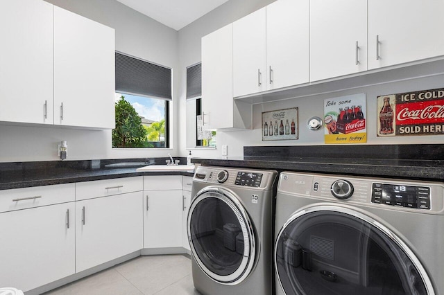 clothes washing area featuring sink, cabinets, light tile patterned floors, and separate washer and dryer