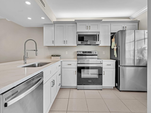 kitchen with light stone counters, sink, stainless steel appliances, and light tile patterned flooring