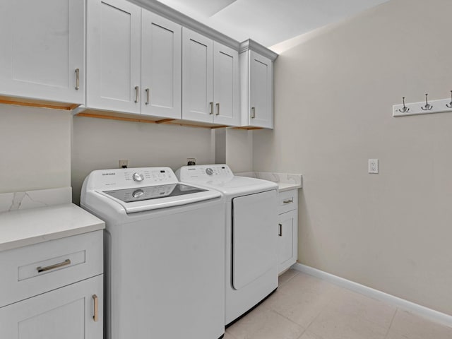 clothes washing area with cabinets and separate washer and dryer