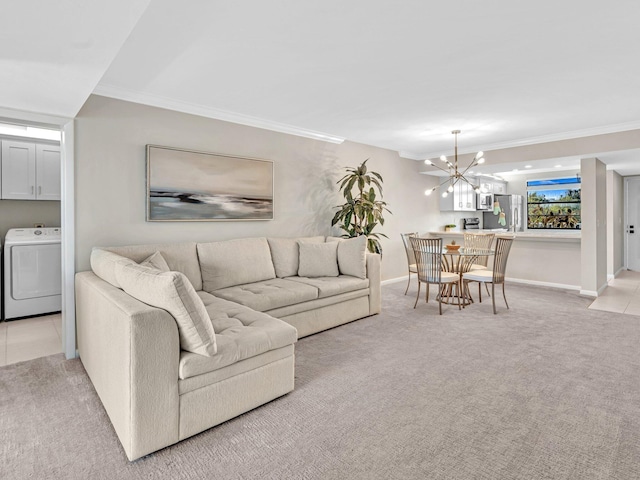 living room with ornamental molding, washer / dryer, light carpet, and a notable chandelier