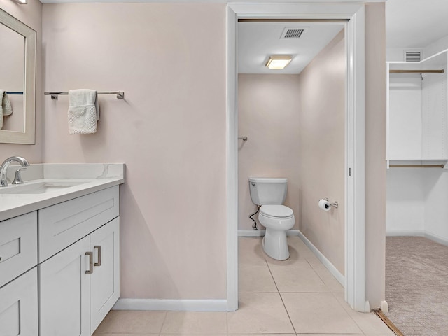 bathroom with tile patterned flooring, vanity, and toilet